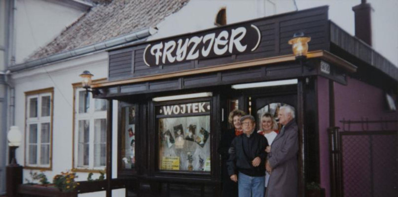 Aleksander (Wojtek) Wójtowicz (w dżinsach) przed swoim zakładem fryzjerskim na ul. Bohaterów Monte Cassiono, Sopot 1994 r. / Materiały Muzeum Sopotu