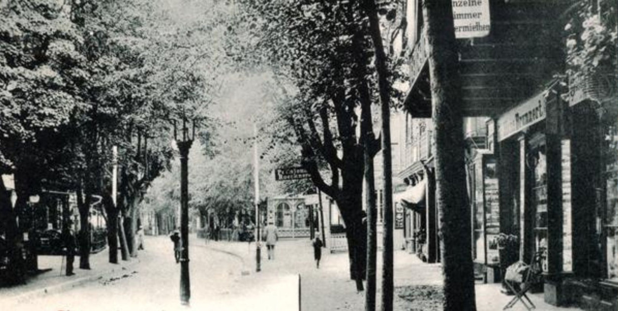 Dolny odcinek ul. Morskiej, na wysokości Willi Bellevue, należącej do Alberta Kubasiaka. Widoczny szyld mieszczącej się na parterze drogerii i pasmanterii Hansa Brunnerta, sprzedającej między innymi sopockie widokówki. Zdjęcie z ok. 1900 r.  (KC), za: www.dawnysopot.pl.