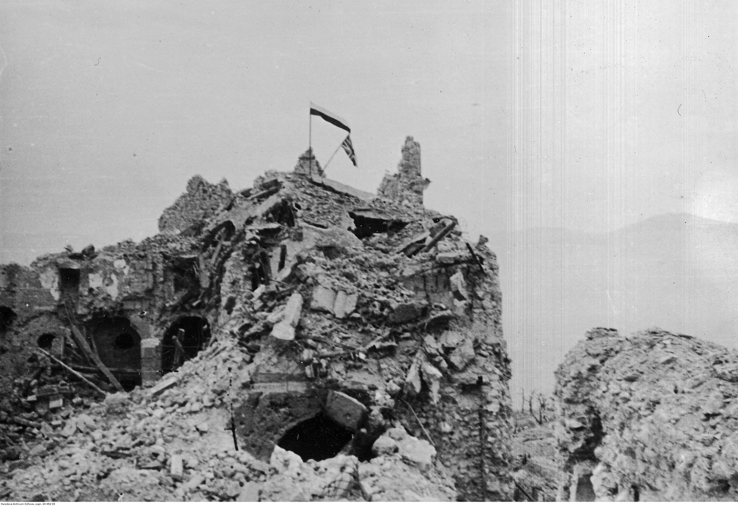 Flagi polska i brytyjska powiewające nad ruinami klasztoru na Monte Cassino. Archiwum Fotograficzne Tadeusza Szumańskiego. Sygnatura: 24-452-15. Narodowe Archiwum Cyfrowe / Domena publiczna