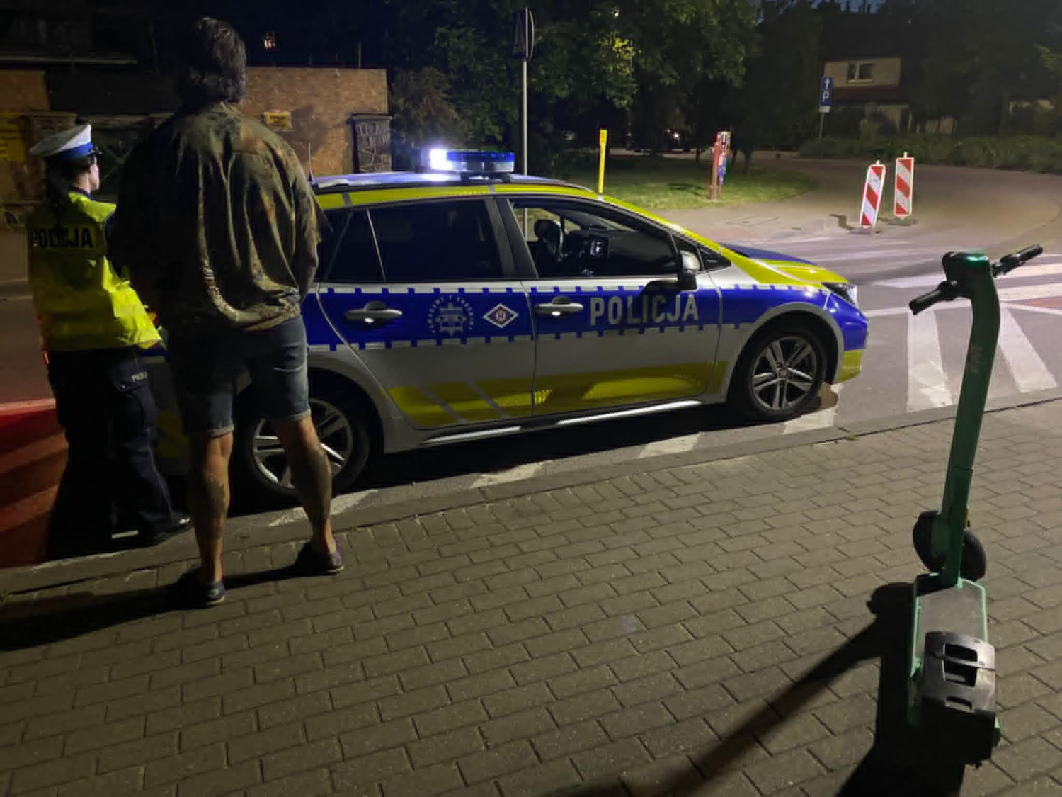 Policyjna kontrola. Na zdjęciu widać funkcjonariuszkę policji oraz mężczyznę stojących obok hulajnogi i radiowozu. Fot. Komenda Wojewódzka Policji w Gdańsku