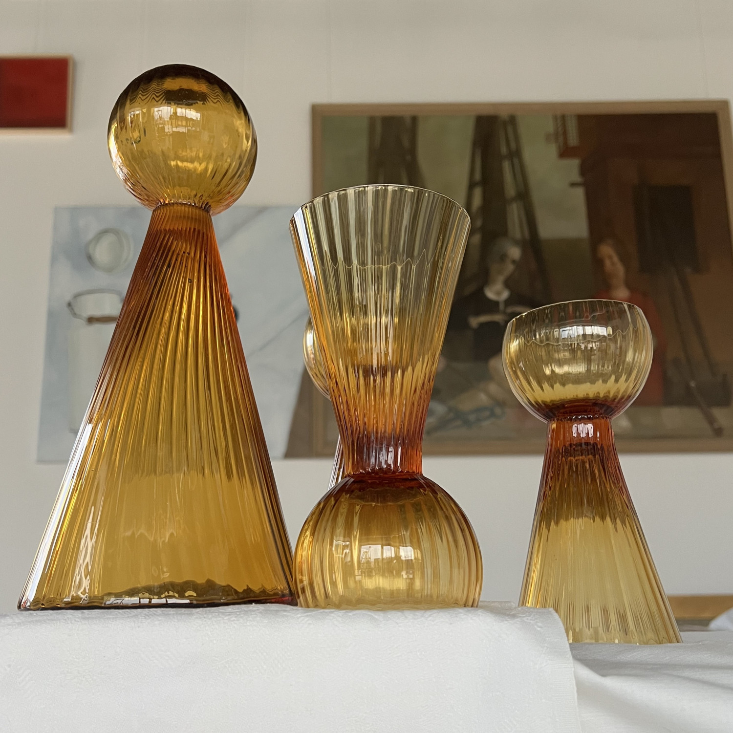 Zestaw Kometa – karafka i dwustronne kieliszki – Aleksandra Kujawska. W tle fragment obrazu Złożenie do grobu w tonacji brązowej, Kiejstut Bereźnicki. Zestaw Kometa – karafka i dwustronne kieliszki – Aleksandra Kujawska. W tle fragment obrazu Złożenie do grobu w tonacji brązowej, Kiejstut Bereźnicki.